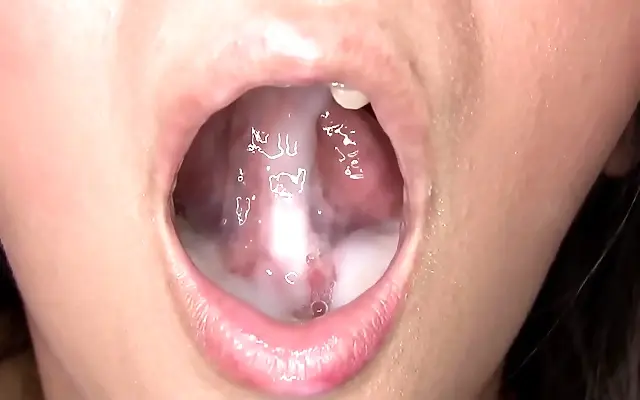 Silver navel ring glints as she savors every drop on her knees