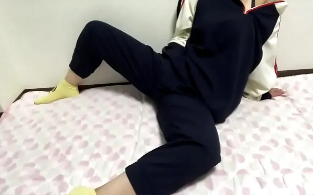 Sunlight spills across her bare legs as she strokes slowly on the dorm bed